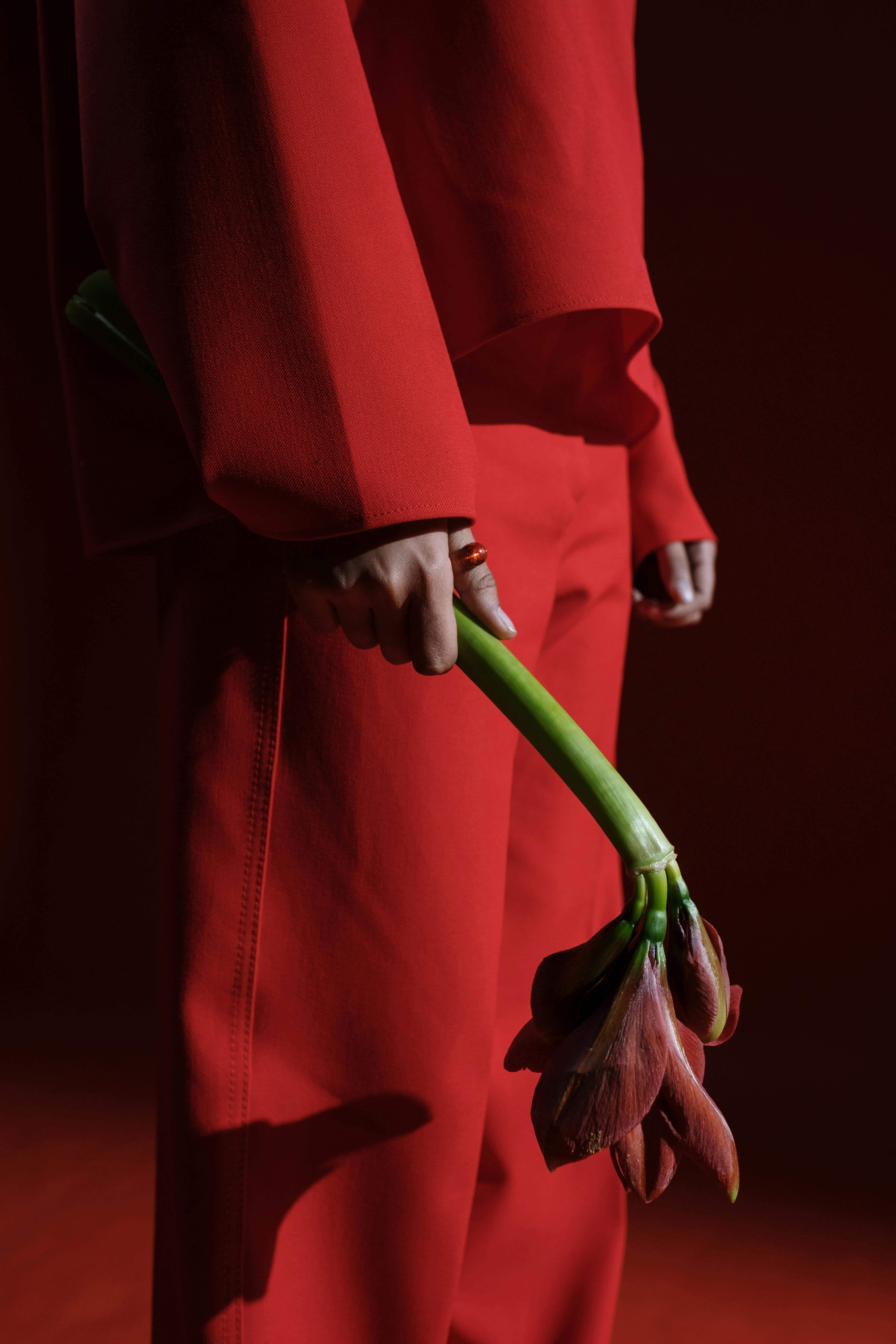 woman in a suit holding a flower