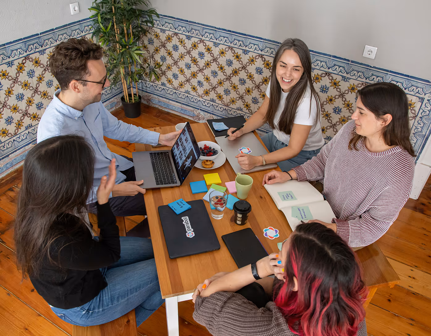 Startup team working together around a table using laptops while planning Flowpay’s digital payment platform.