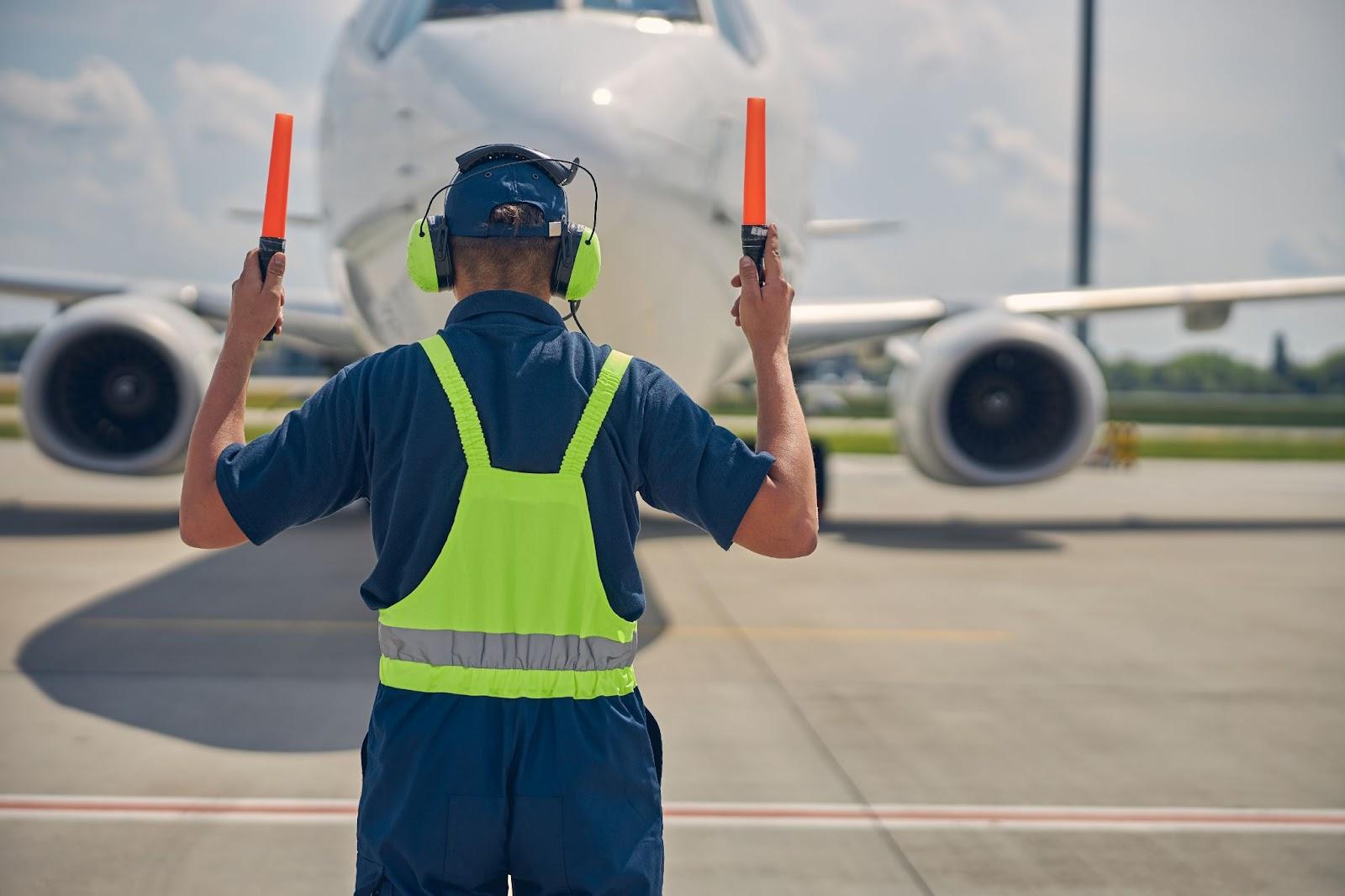 Aviation marshall wearing hearing protection on the tarmac