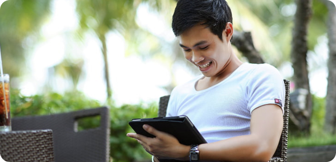 Smiling man watching at tablet.