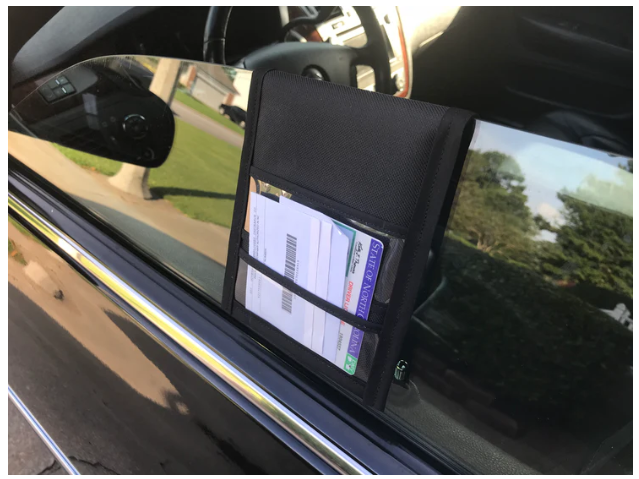 The image is a Pullover Pal organizer hung from the driver’s side window. Image credit: Pullover Pal