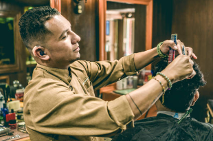 A man with hearing aid as a hairdresser.