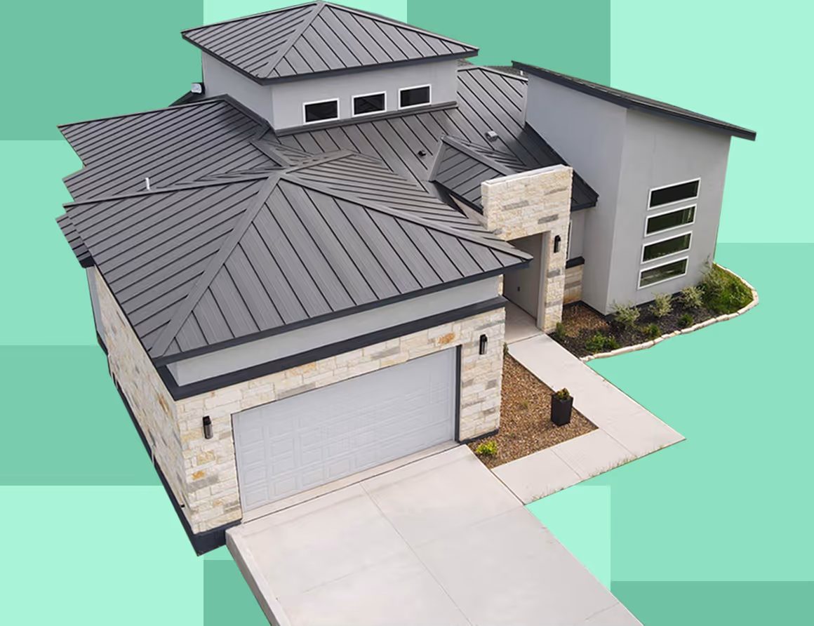 Modern single-story house with gray metal hip roofs, stone and gray exterior walls, a driveway, and a front walkway with landscaping.