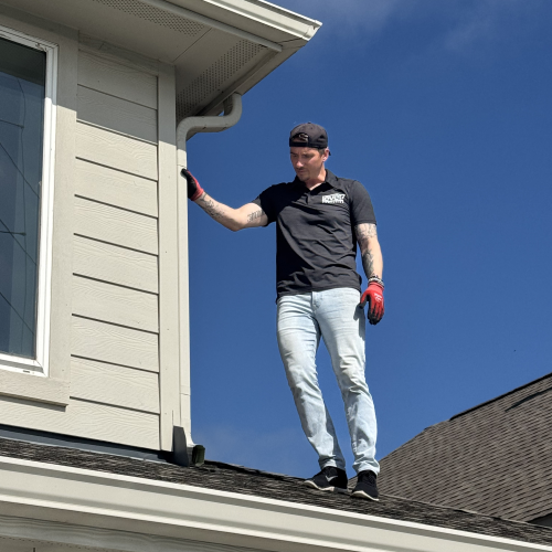 Technician repairing roof gutter system damaged by hail