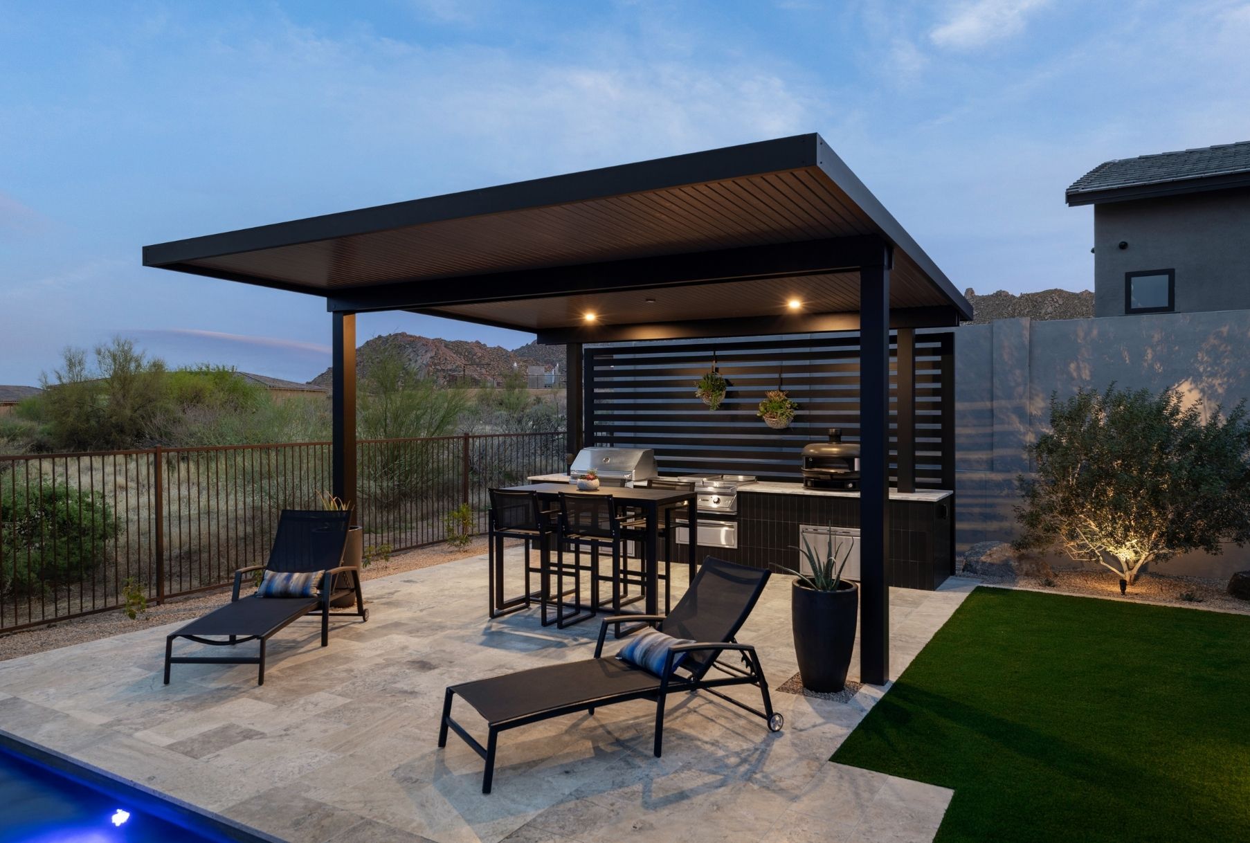 Custom patio cover and outdoor kitchen with chairs