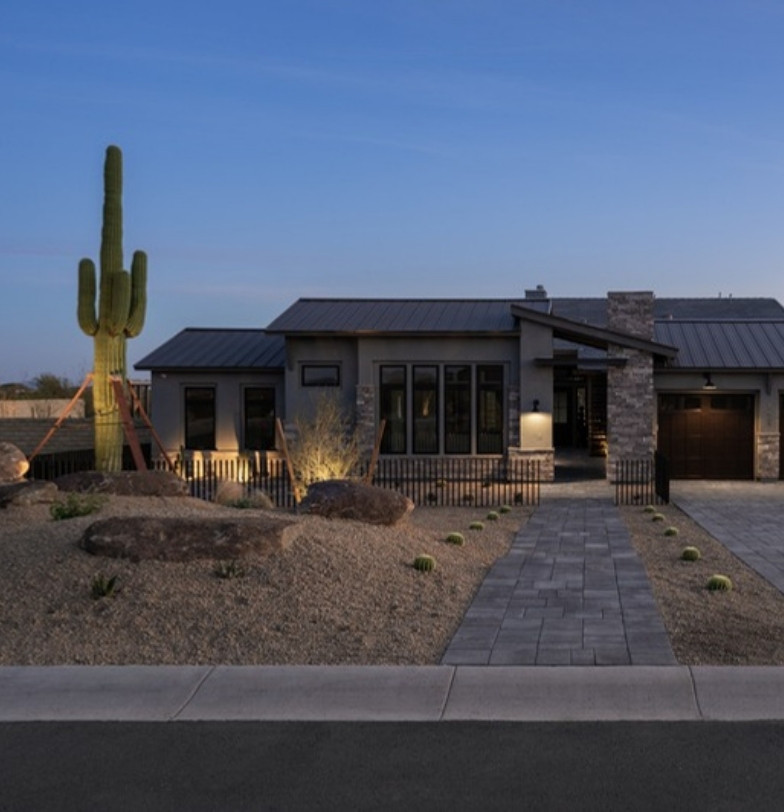Desert front yard with saguaro, boulders and paver walkway at dusk by Kevens Landscape