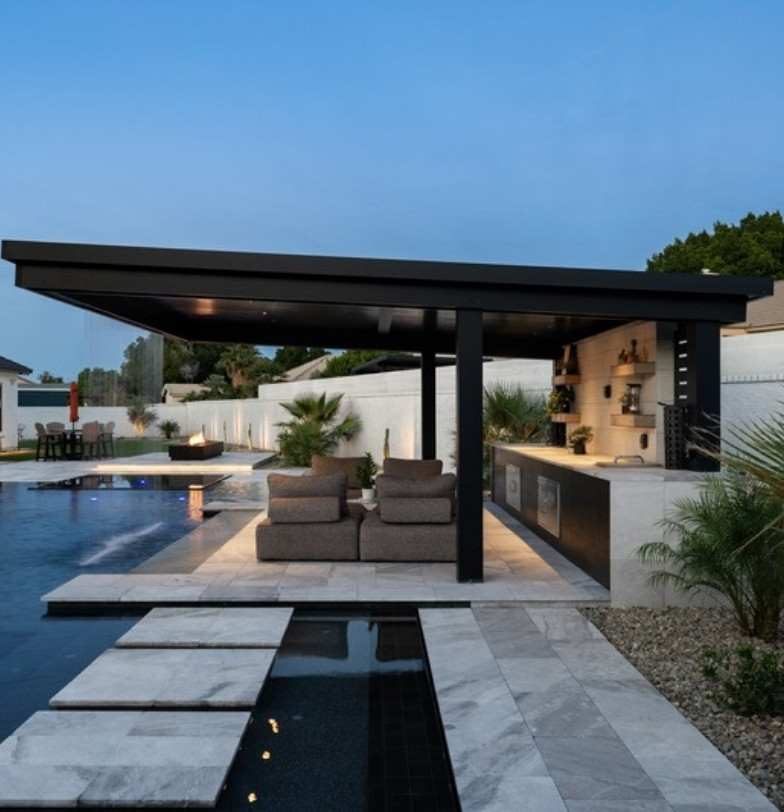 Pool with floating stepping pads and covered ramada with outdoor kitchen by Kevens Landscape