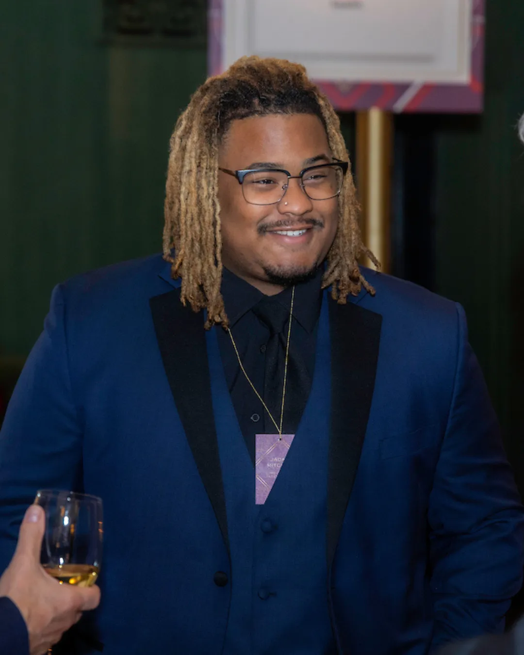Man in a blue suit smiling at an event