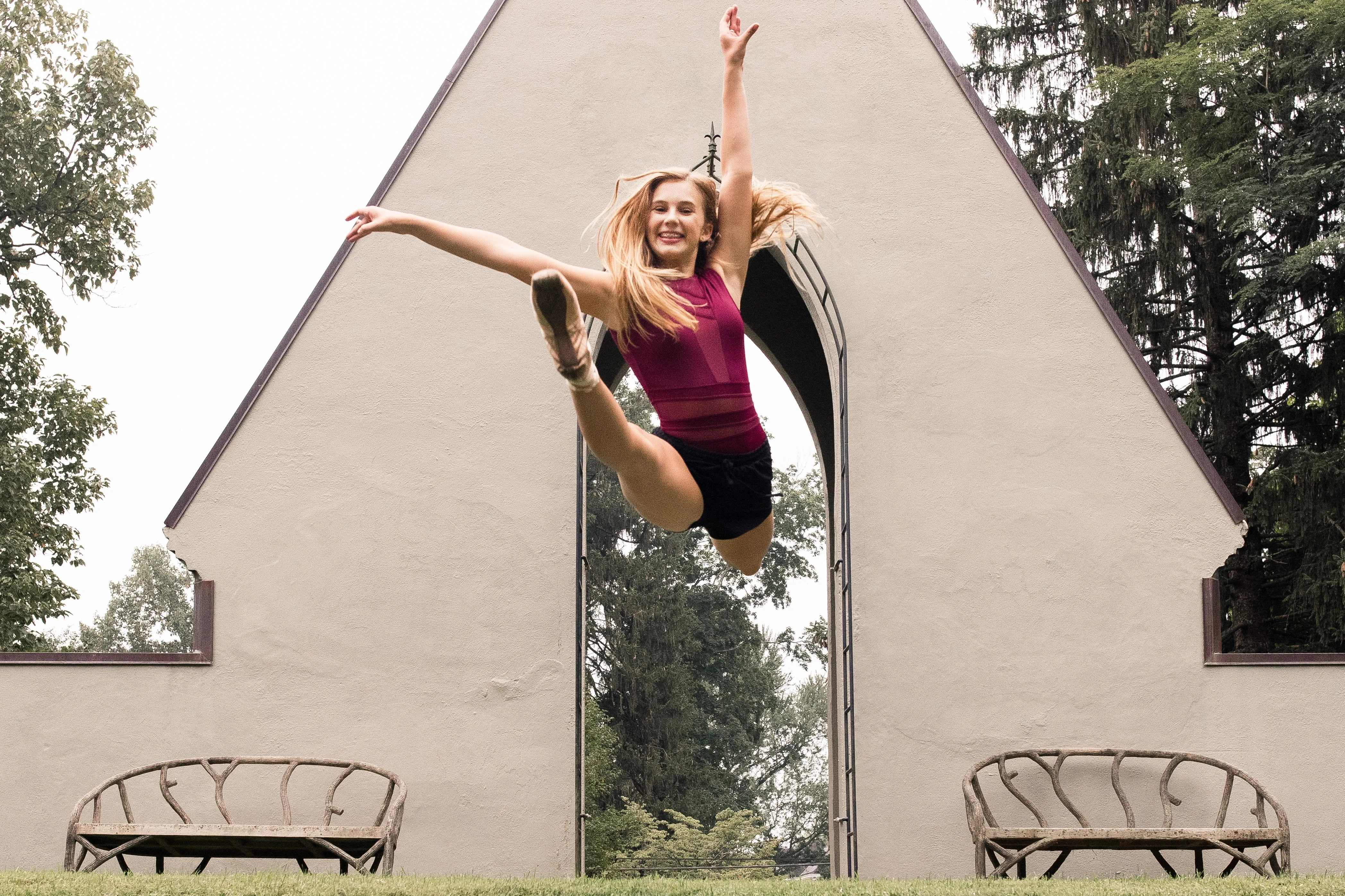 Young dancer performing a high leap outdoors