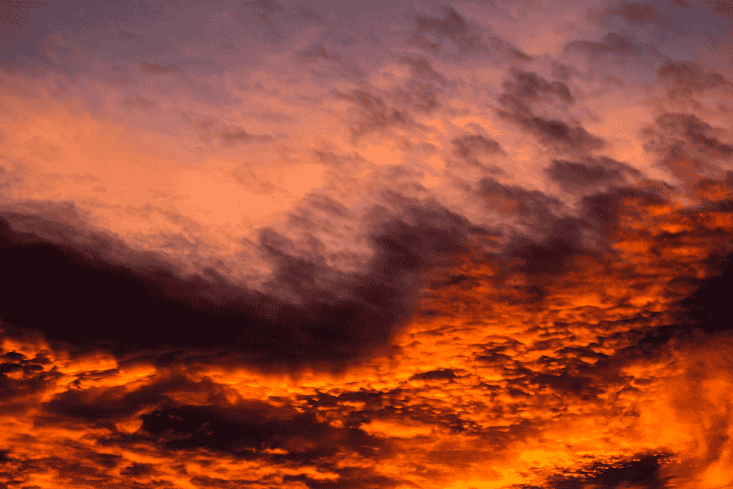 Dramatic sunset sky with orange and purple clouds creating a textured pattern.