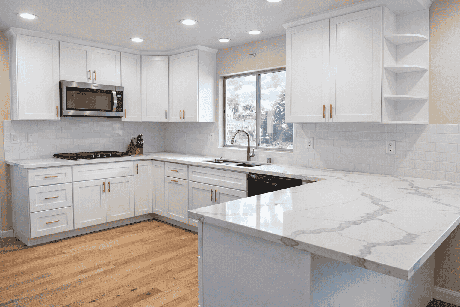 Modern bathroom with a double vanity featuring white cabinets, marble countertop, two sinks, a large mirror, and a glass-enclosed shower.
