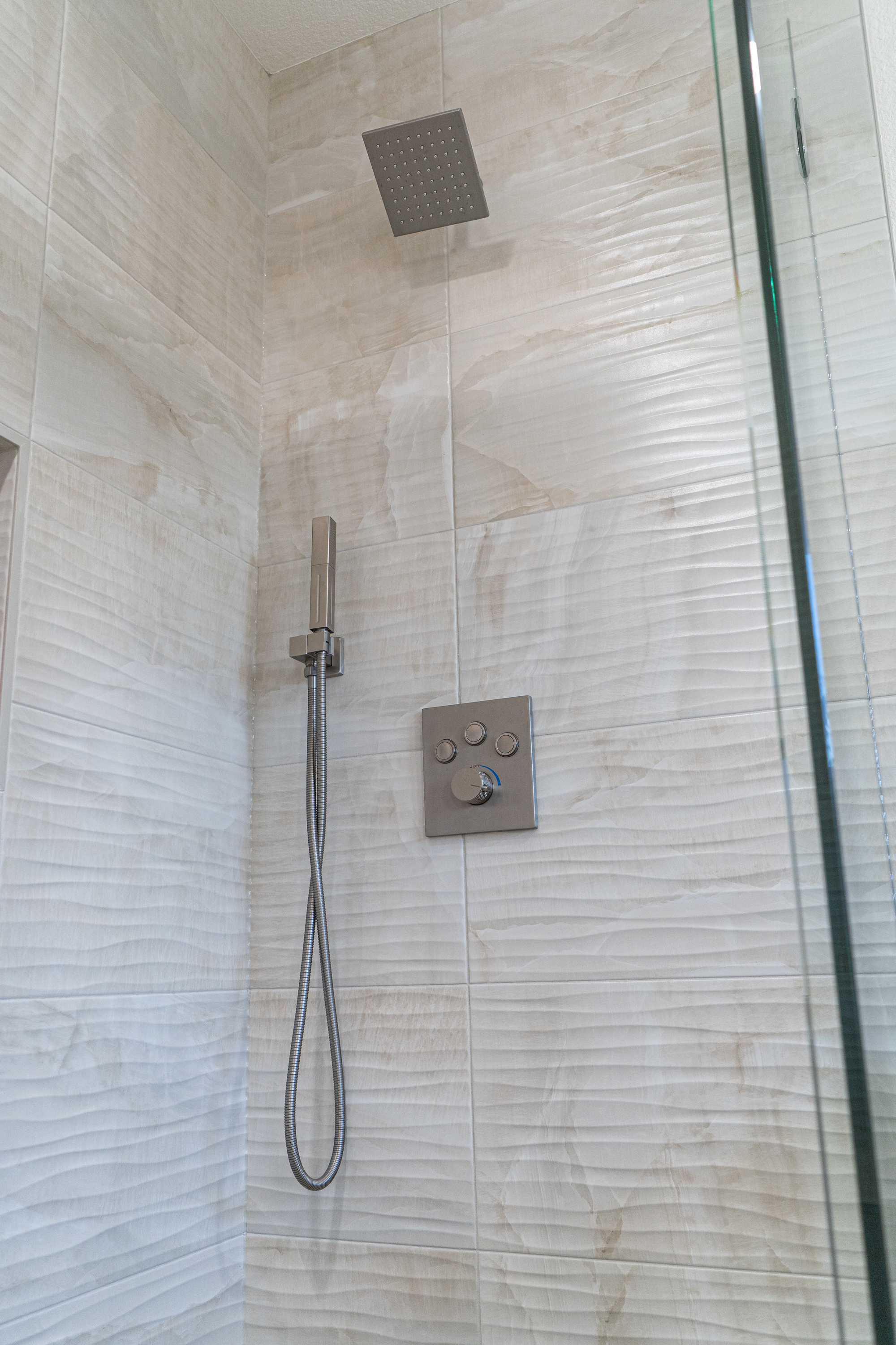 A wide-angle grayscale shot of a kitchen island with three wooden barstools.