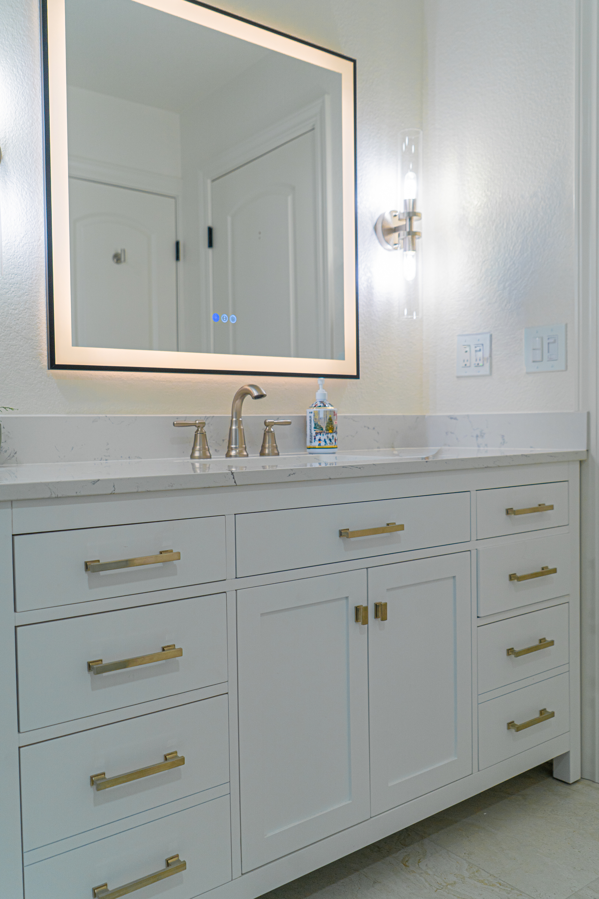 A grayscale photo of a kitchen sink with a high-arc faucet and tile backsplash.