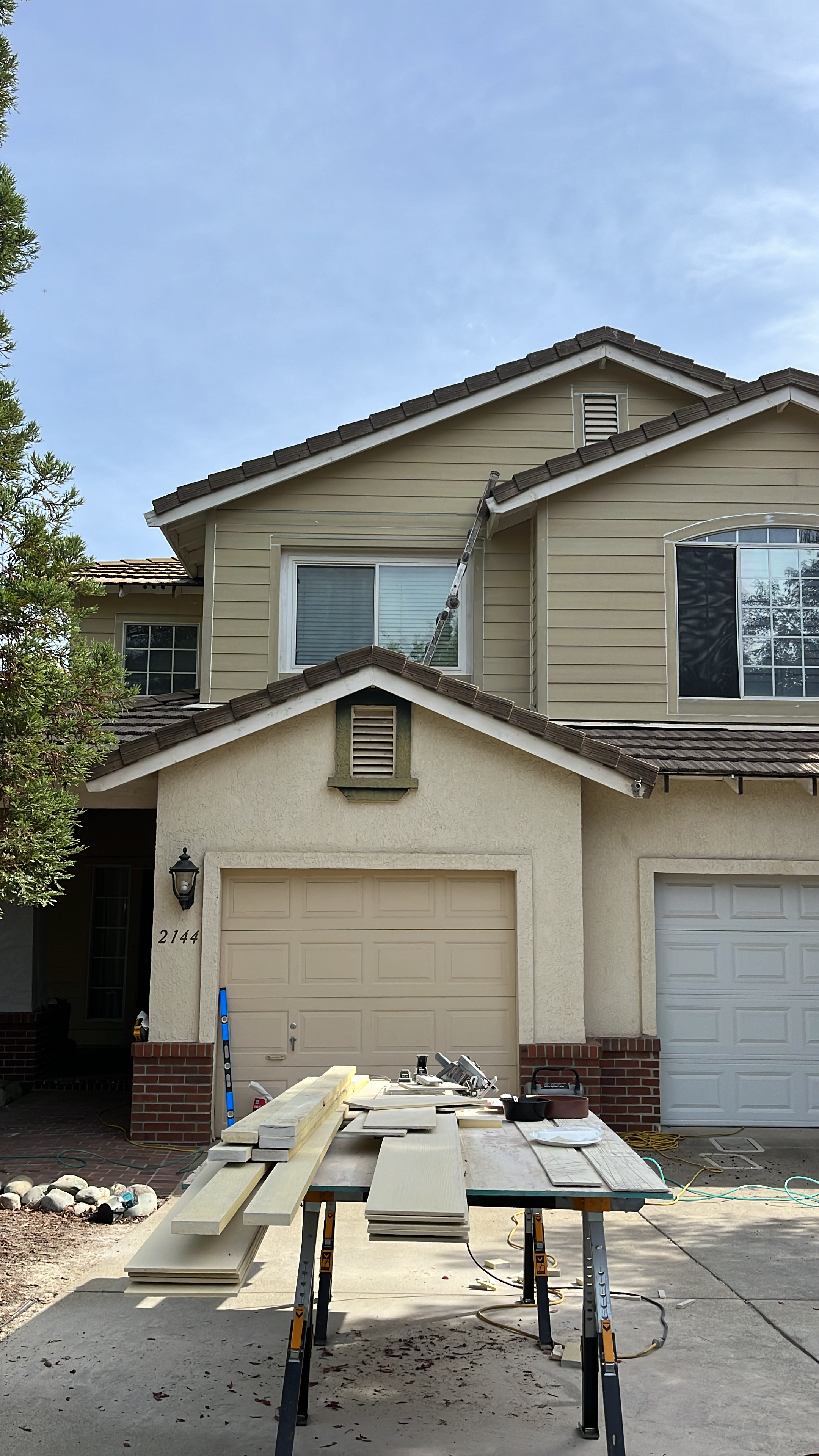 Modern Sacramento bathroom with a large bathtub, double sink vanity with cluttered countertop, tile flooring, and glass shower enclosure.