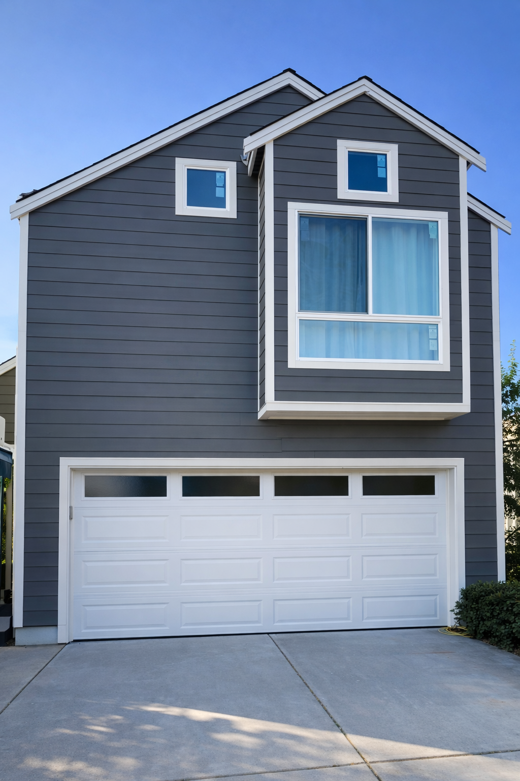Modern kitchen with white cabinets, marble-patterned countertops, stainless steel microwave, gas stove, and a window above the sink.