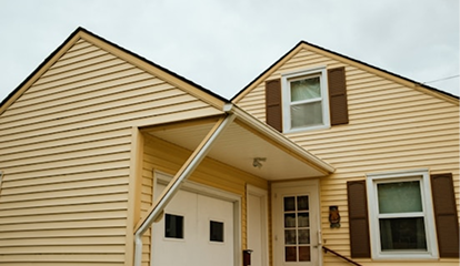 A grayscale photo of wooden kitchen shelves holding various bowls and carafes.