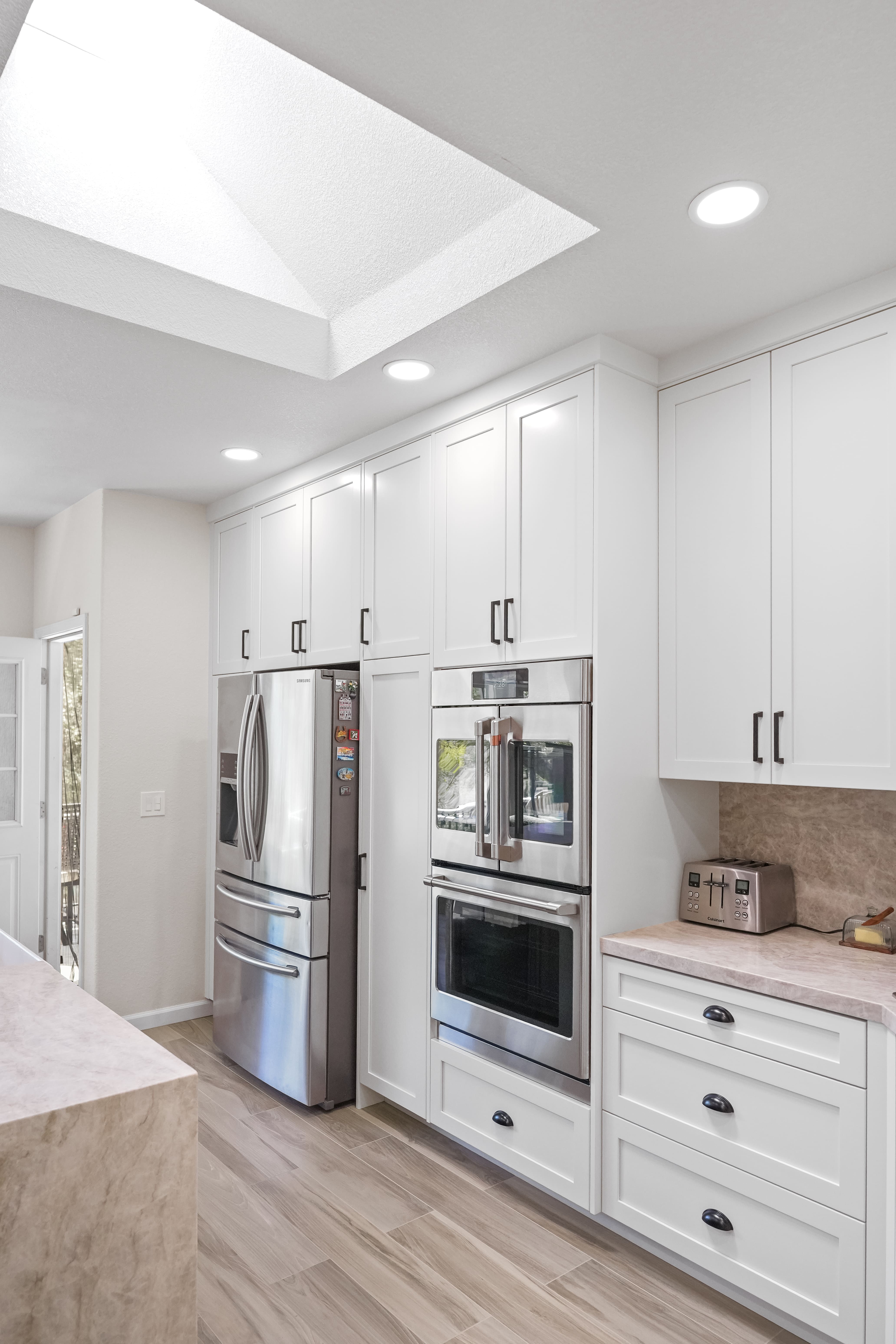 A grayscale photo of a kitchen sink with a high-arc faucet and tile backsplash.