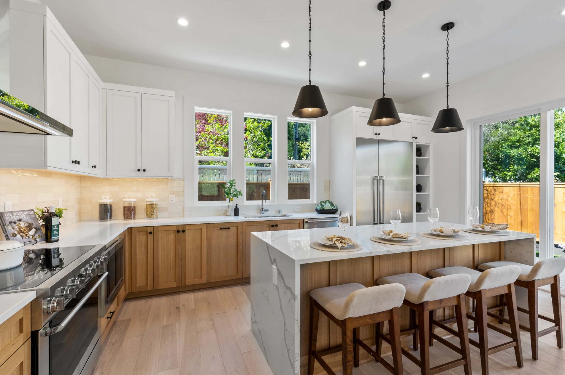 A bright grayscale photograph of a modern kitchen with marble-patterned island.