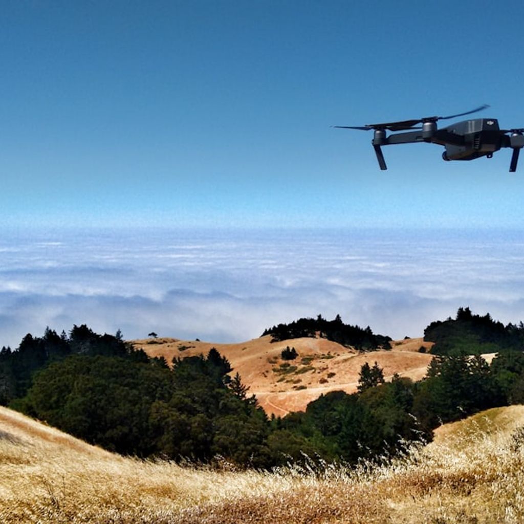 Asset investor reviewing defense drone rental opportunity with autonomous UAV on launch pad in open field