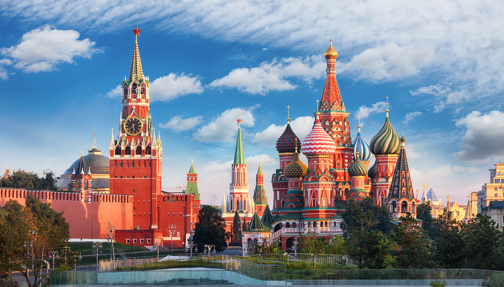 View of Saint Basil's Cathedral and Kremlin towers under a blue sky in Moscow, Russia.