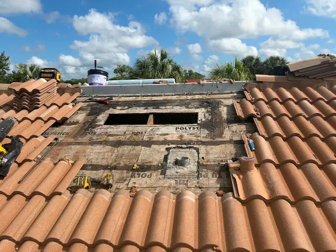 Bonita Springs tile roof opened up for repair with the deck and underlayment exposed around failed off-ridge and gooseneck vents