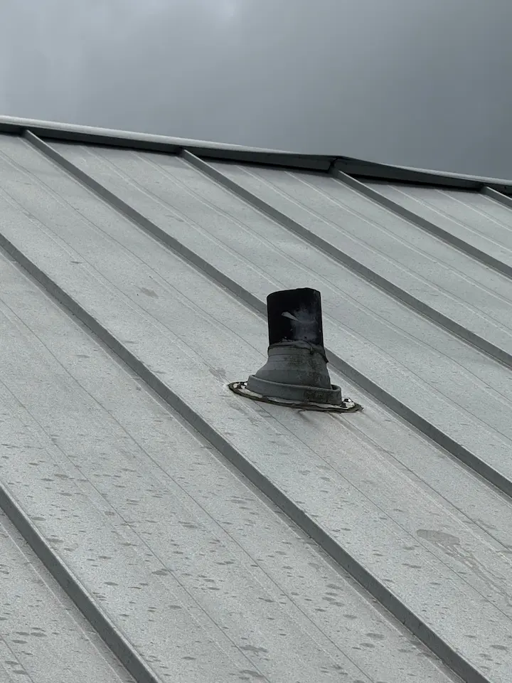 Aging, cracked EPDM pipe boot on a standing seam metal roof in Bonita Springs