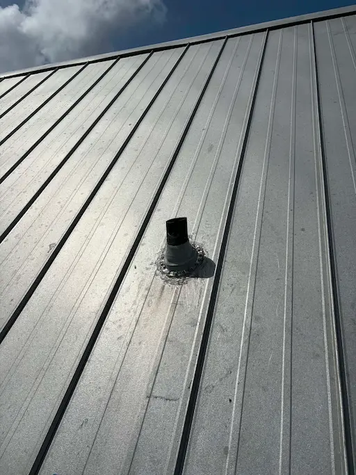 New pipe boot resealed on a standing seam metal roof in Bonita Springs