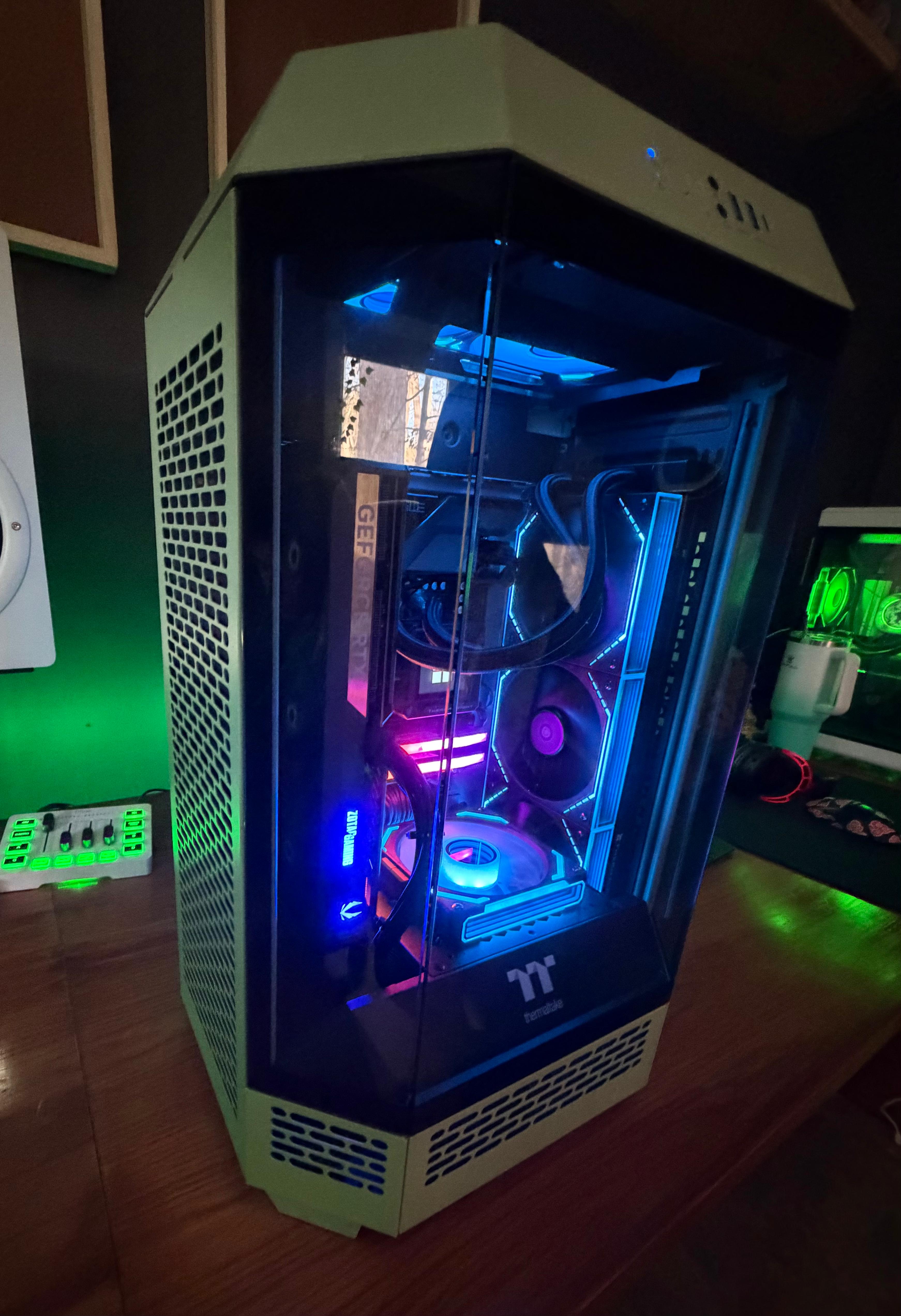 Gaming PC tower with transparent side panel showing illuminated internal components and RGB lighting.