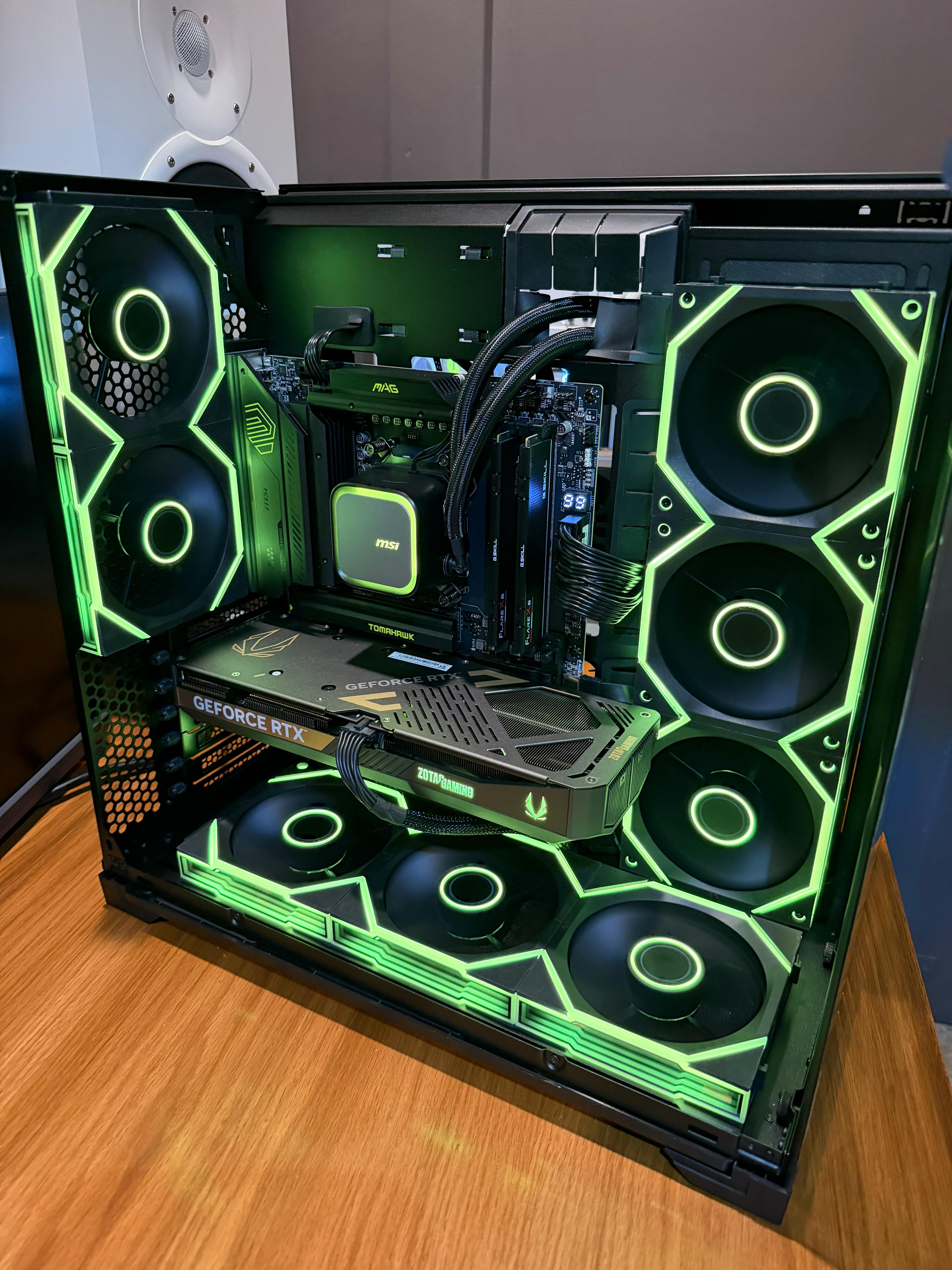 Gaming PC tower with transparent side panel showing illuminated internal components and RGB lighting.