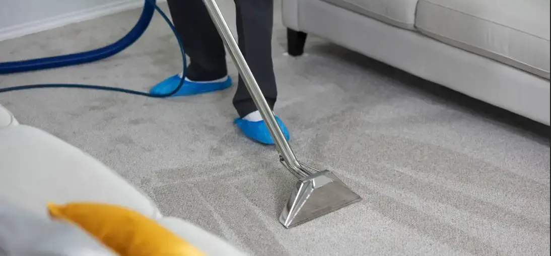 Technician using a hot water extraction wand on carpet