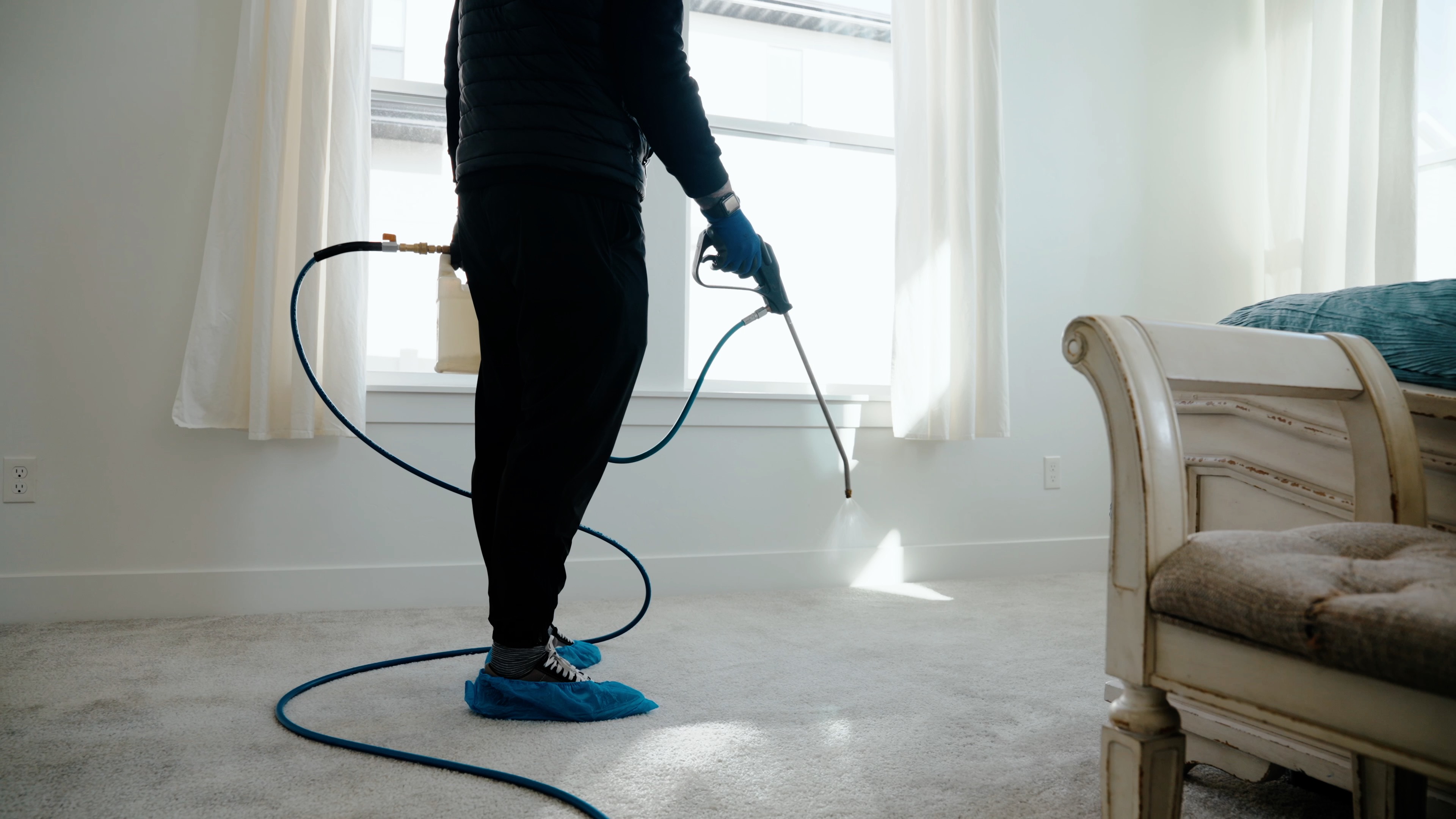 Technician applying pet stain and odor treatment to carpet in a Utah home