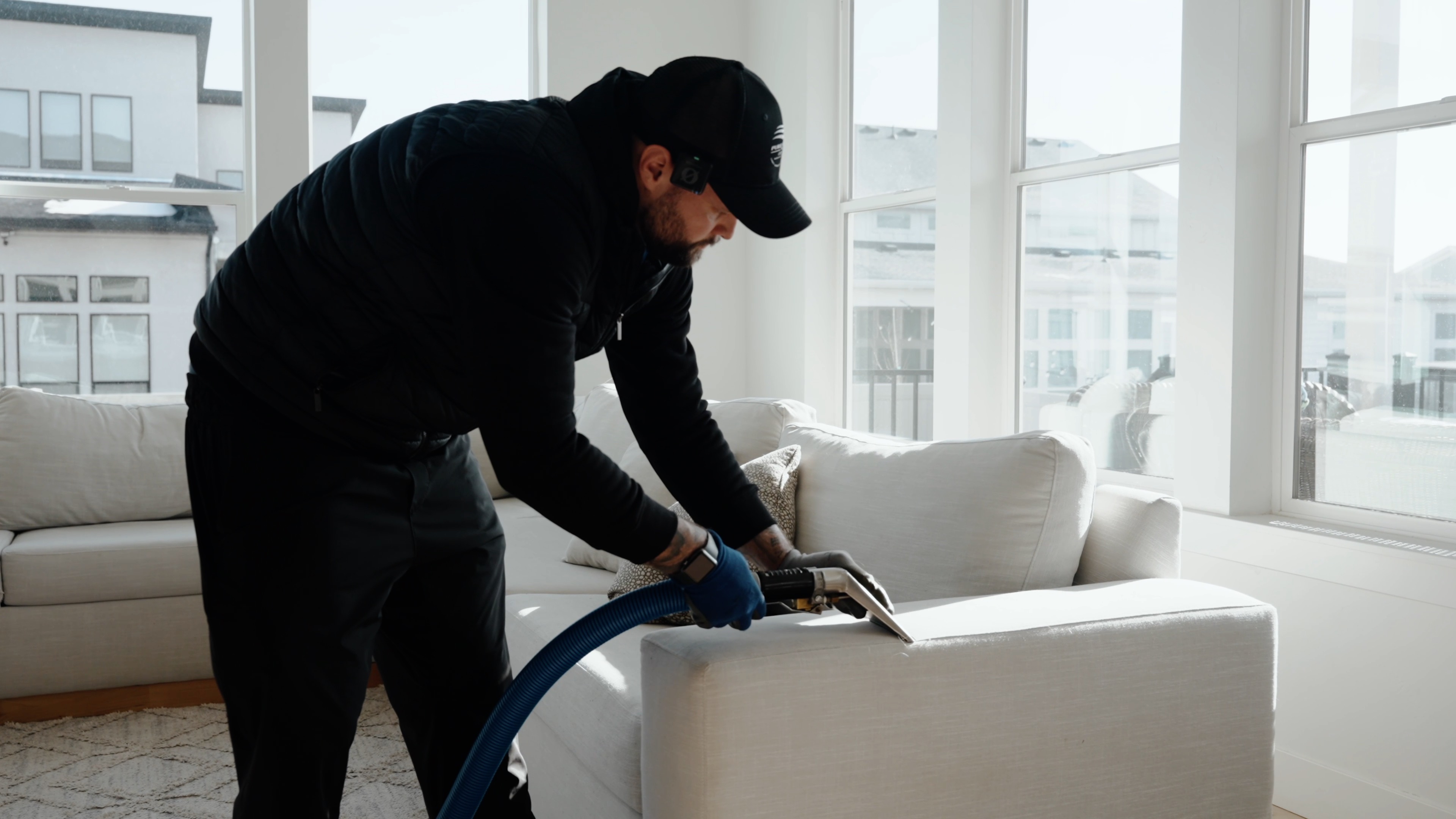 Upholstery cleaning tool extracting dirt from a white couch cushion