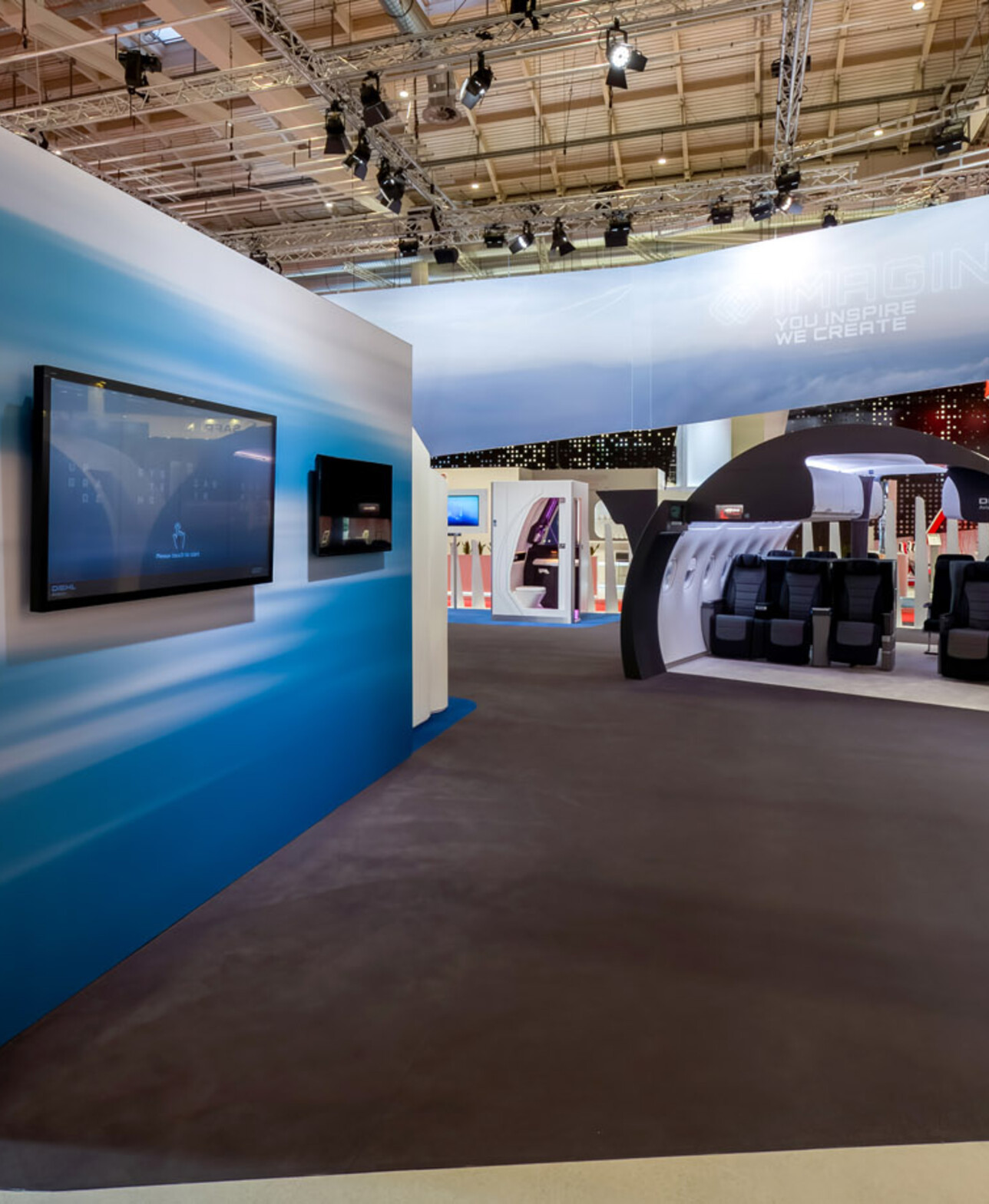 Kabinen-Module und blaue Medienwand im Innenbereich des Diehl-Aviation-Messestands
