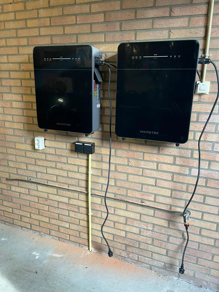 Twee Marstek thuisbatterijen aan een stenen wand, geplaatst door ABGTGREEN