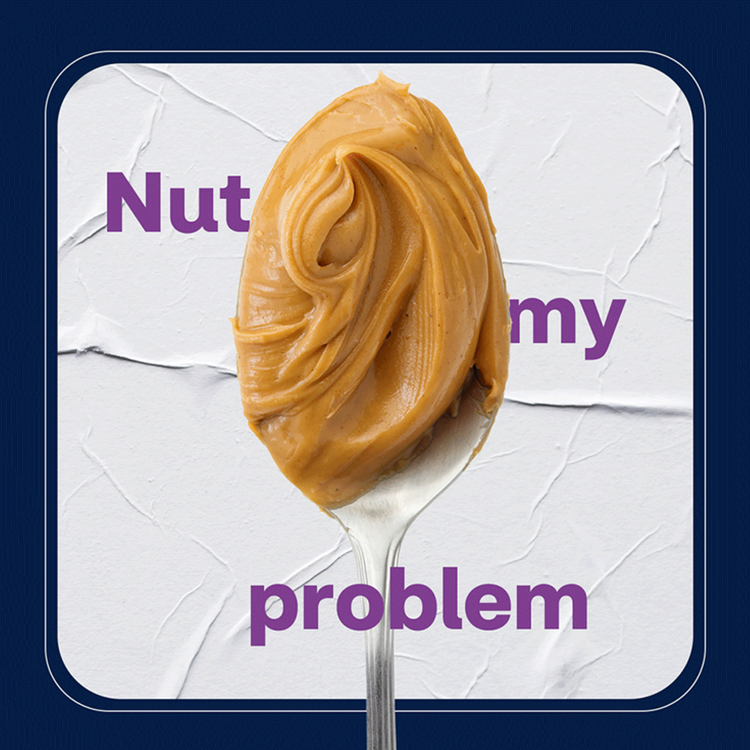 A spoonful of creamy peanut butter with the words 'Nut my problem' partially visible behind it.