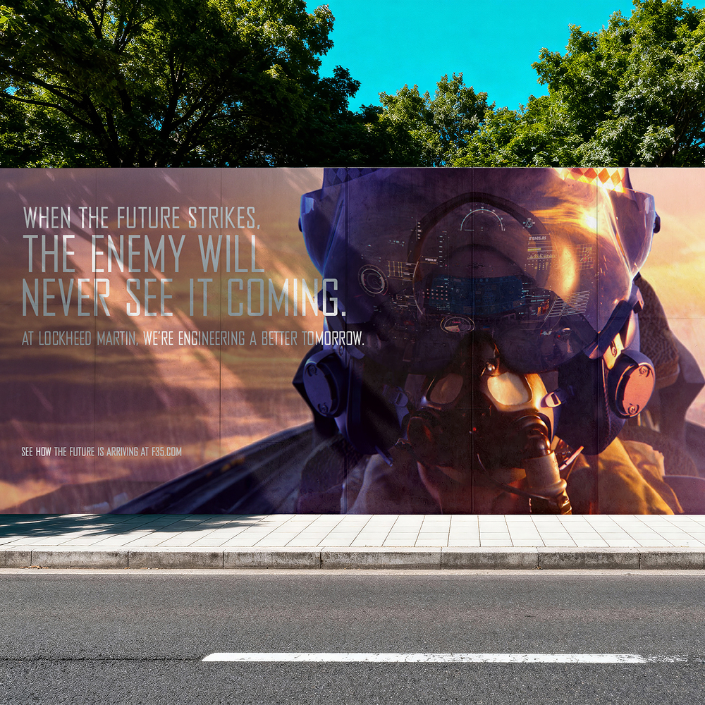 Outdoor billboard showing a pilot with flight helmet and visor, alongside text about Lockheed Martin engineering a better tomorrow.