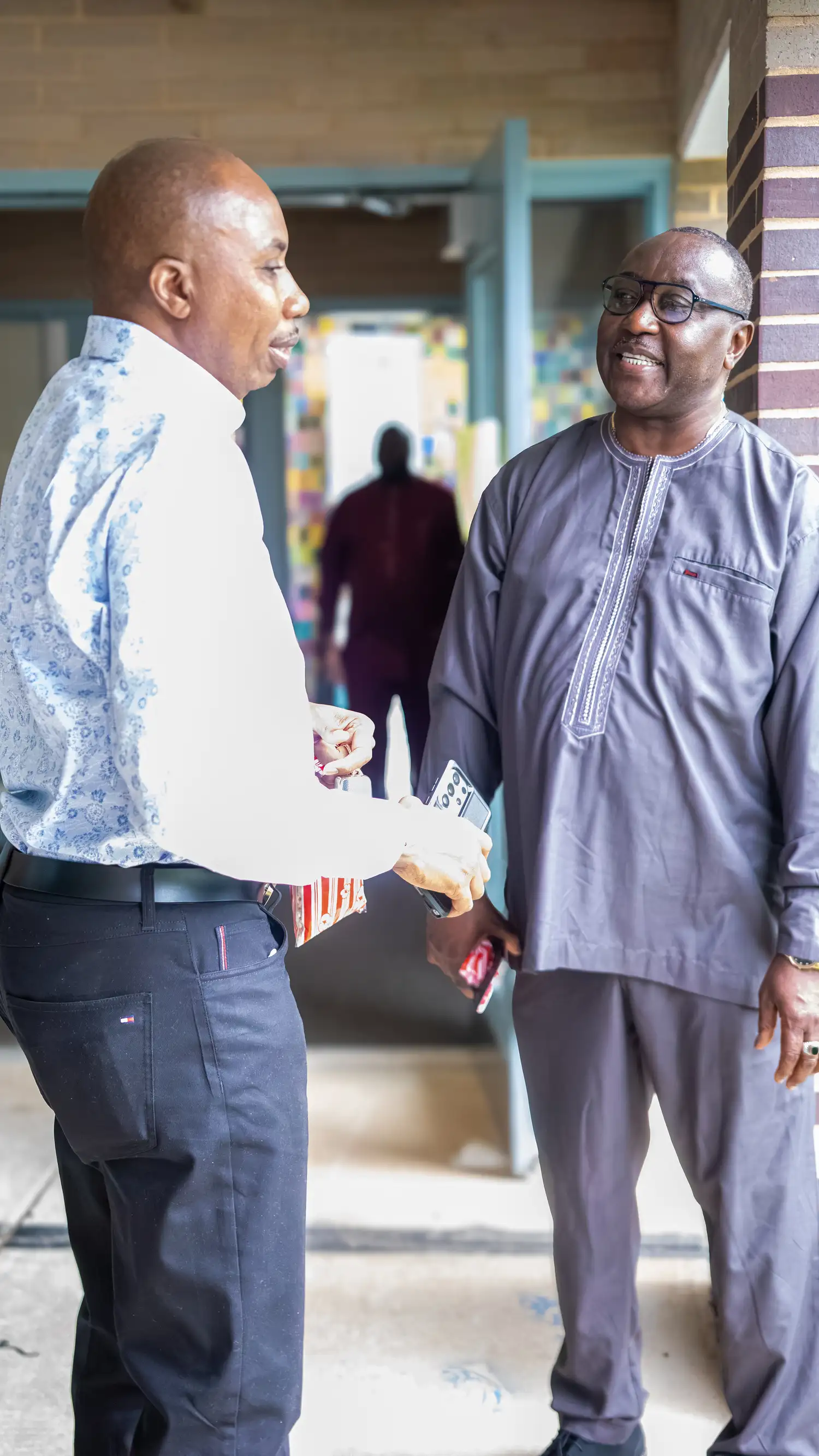 Two men talking together in the covered walkway at Restoration Church in Laurel, Maryland