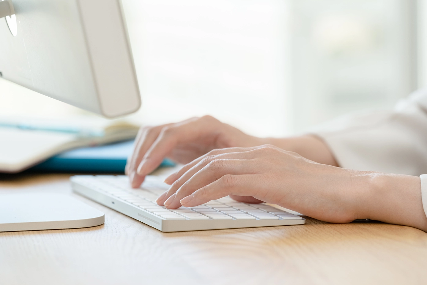 パソコンのキーボードでタイピングしている両手。