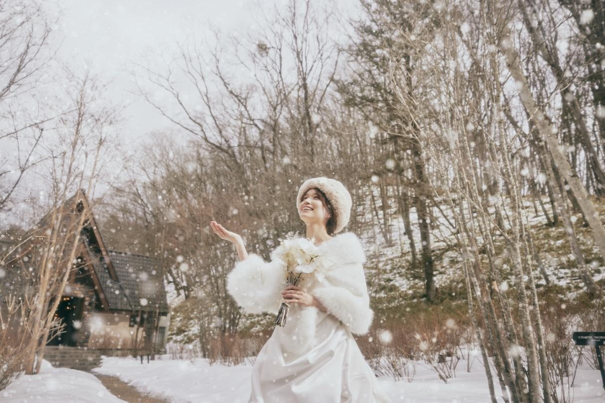 雪が積もっている道に立っている女性低い精度で自動的に生成された説明