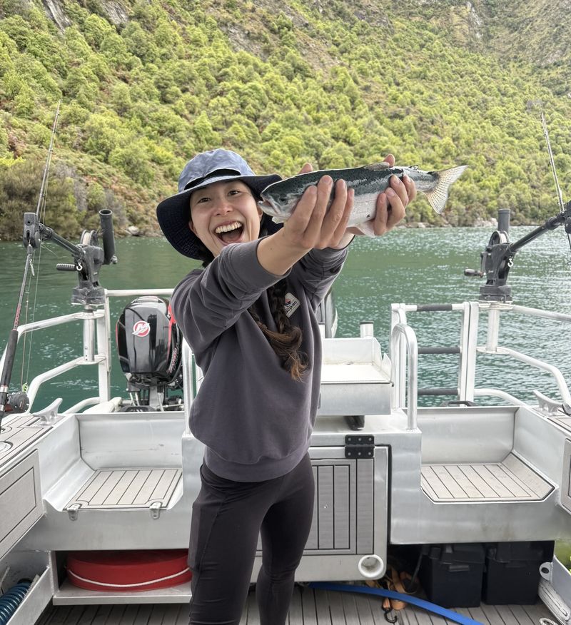 Guest holding her trout catch on Lake Wānaka