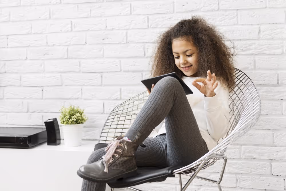 Happy kid reading in a Tablet.