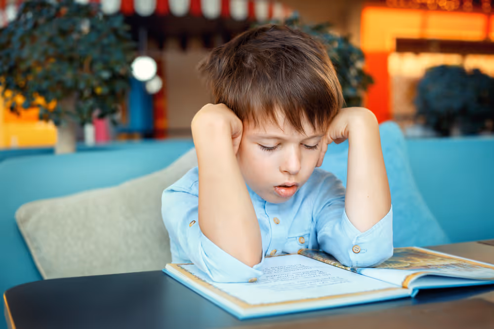 Unhappy kid reading a book.