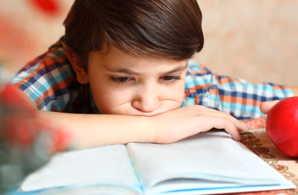 Unhappy kid reading.
