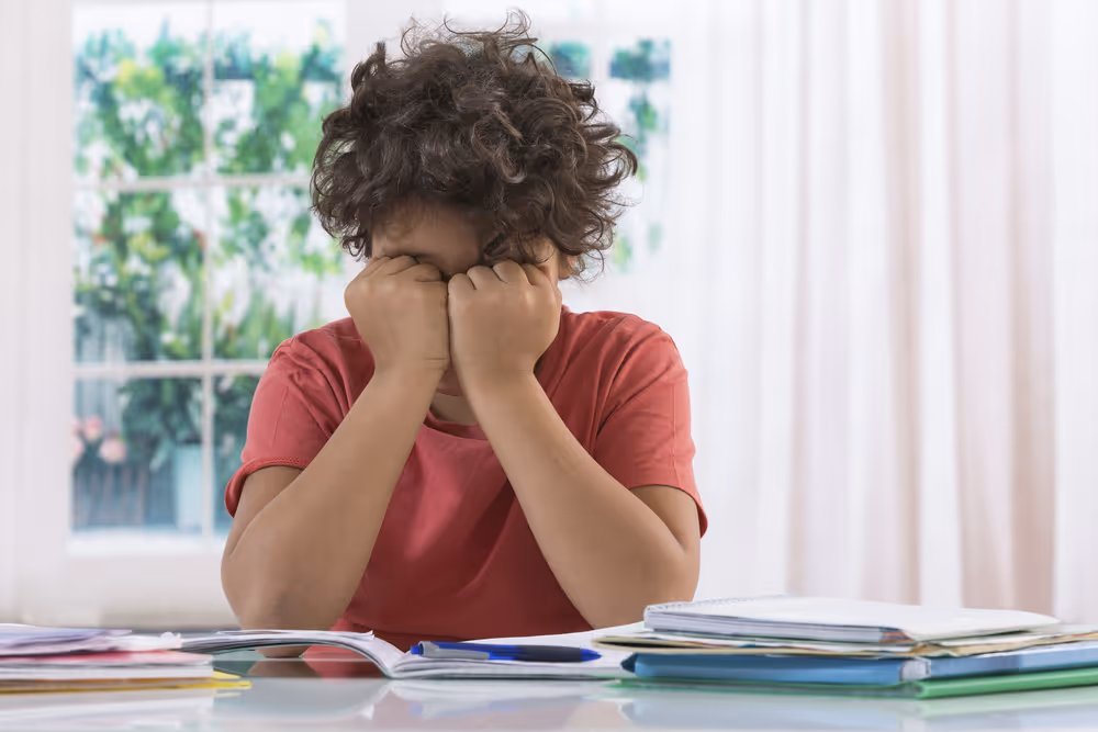 Unhappy kid in reading desk.