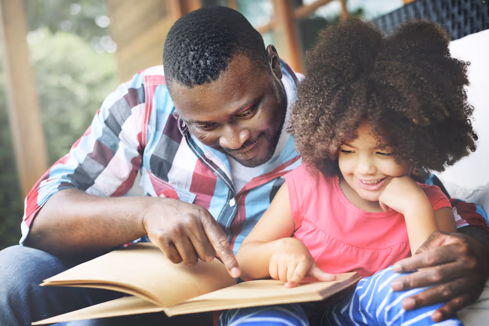 Kid engaging in reading activity in tablet with parent.