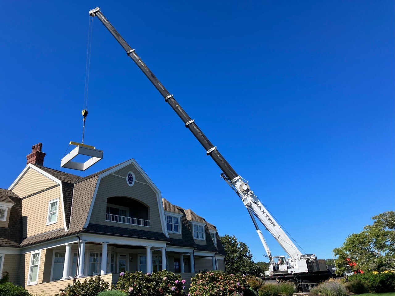 Baxter Crane lifting HVAC unit onto Nantucket-style residential home