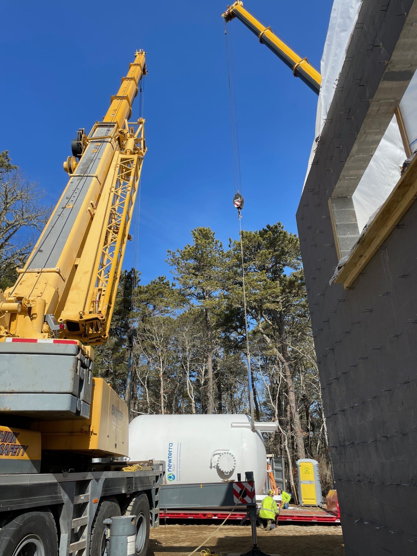 Baxter Crane loading heavy industrial machinery onto flatbed trailer