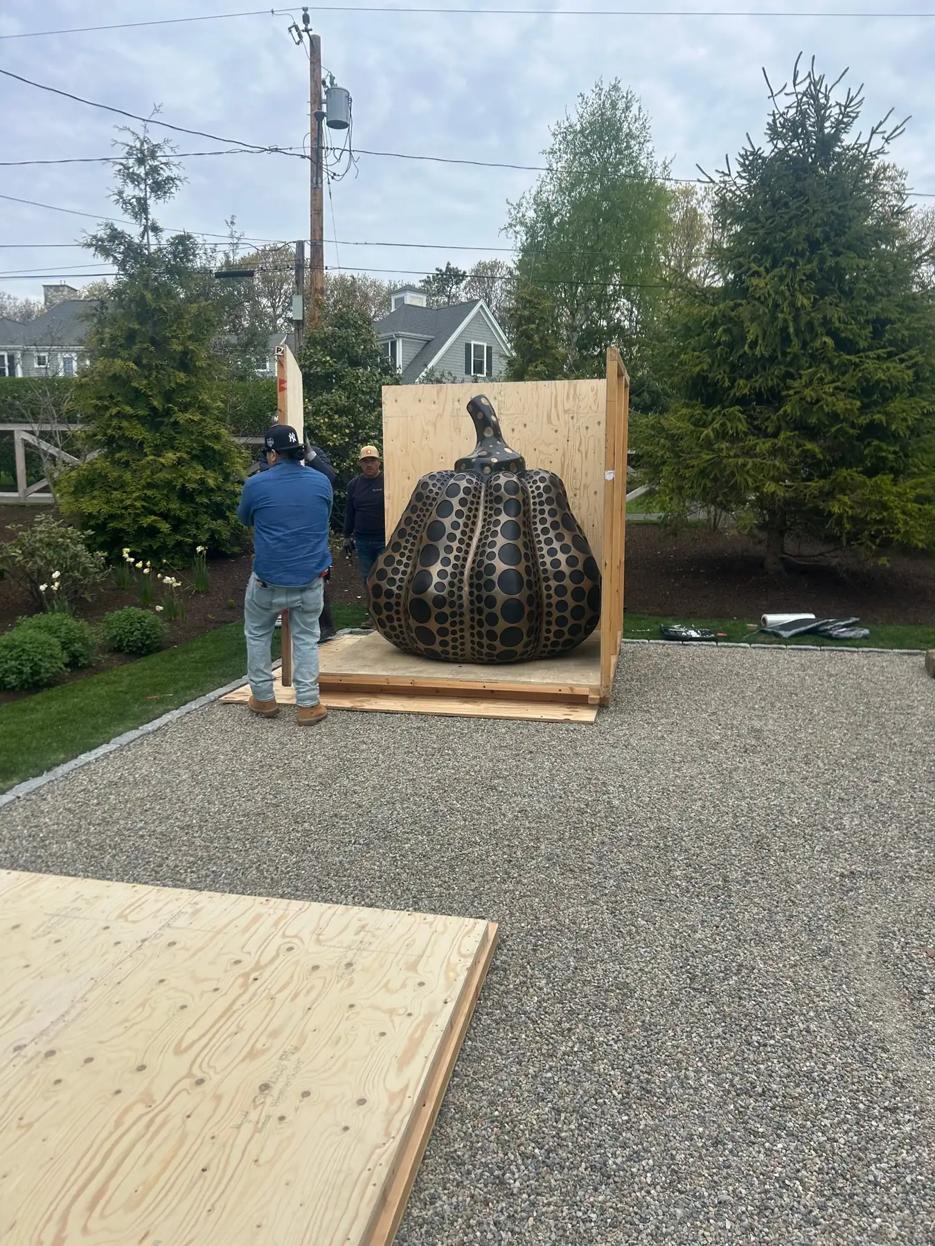 Baxter Crane riggers opening the shipping crate around a Yayoi Kusama pumpkin sculpture in a garden