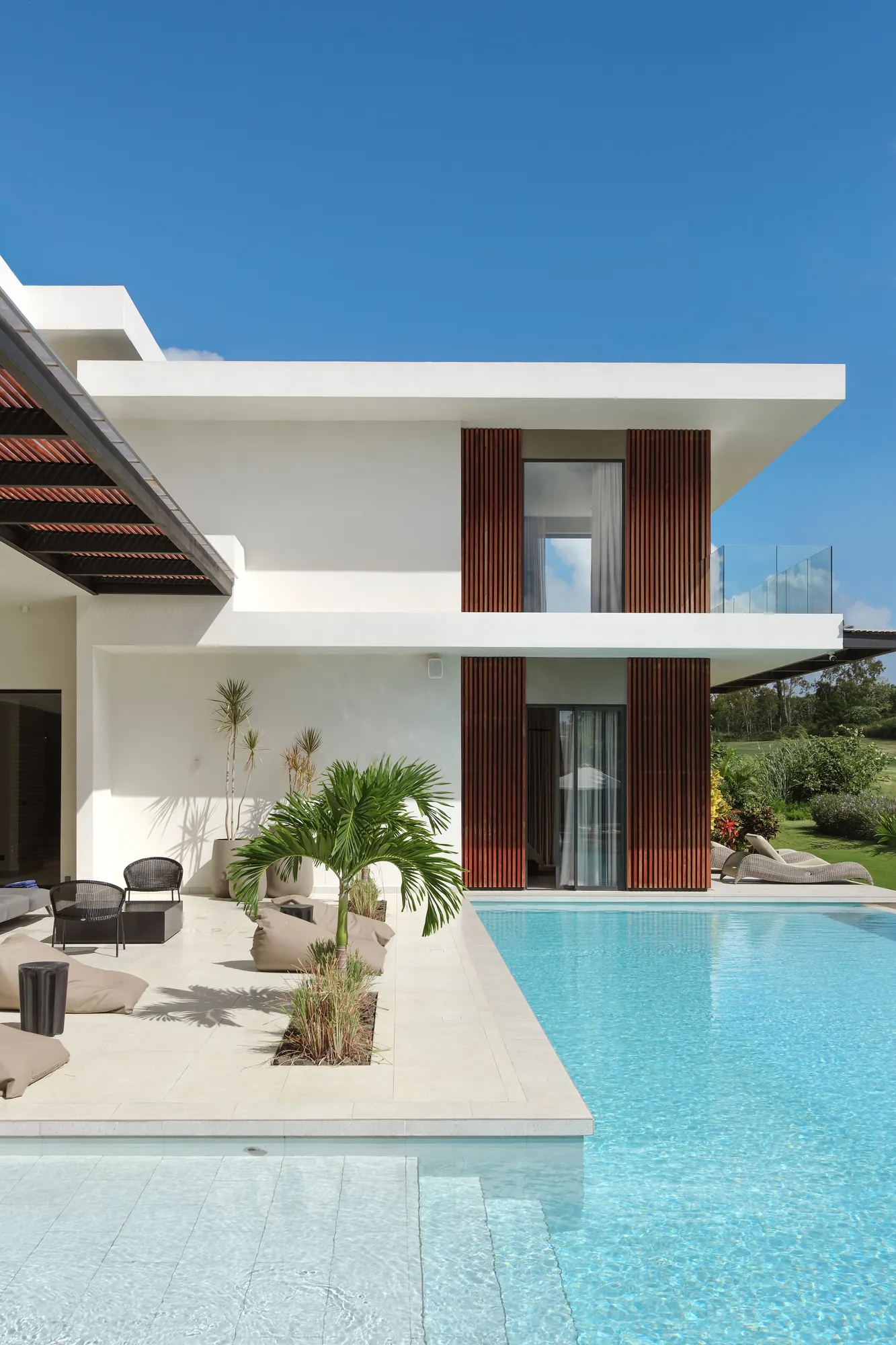 Villa moderne aux claustras en bois, au bord de sa piscine