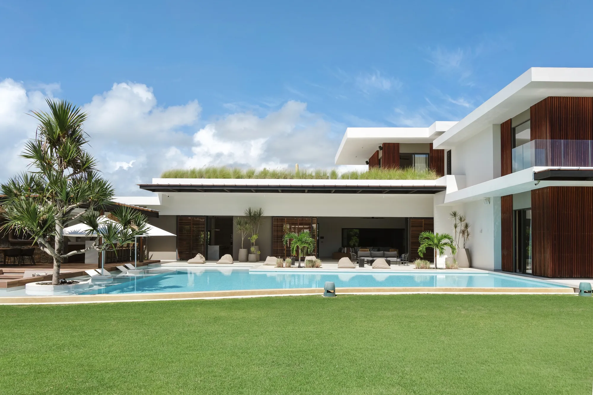 Villa contemporaine et sa piscine, au-delà d'une large pelouse